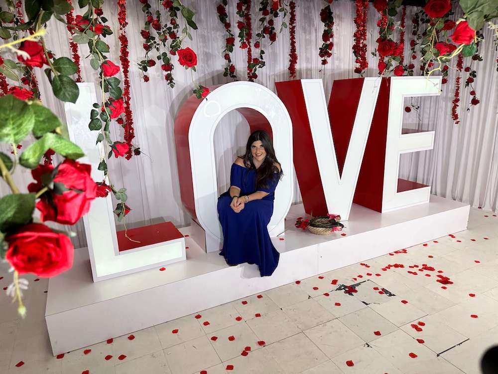 Rachel Rofé sitting in the letter "O" in a large LOVE sign in Houston, Texas.